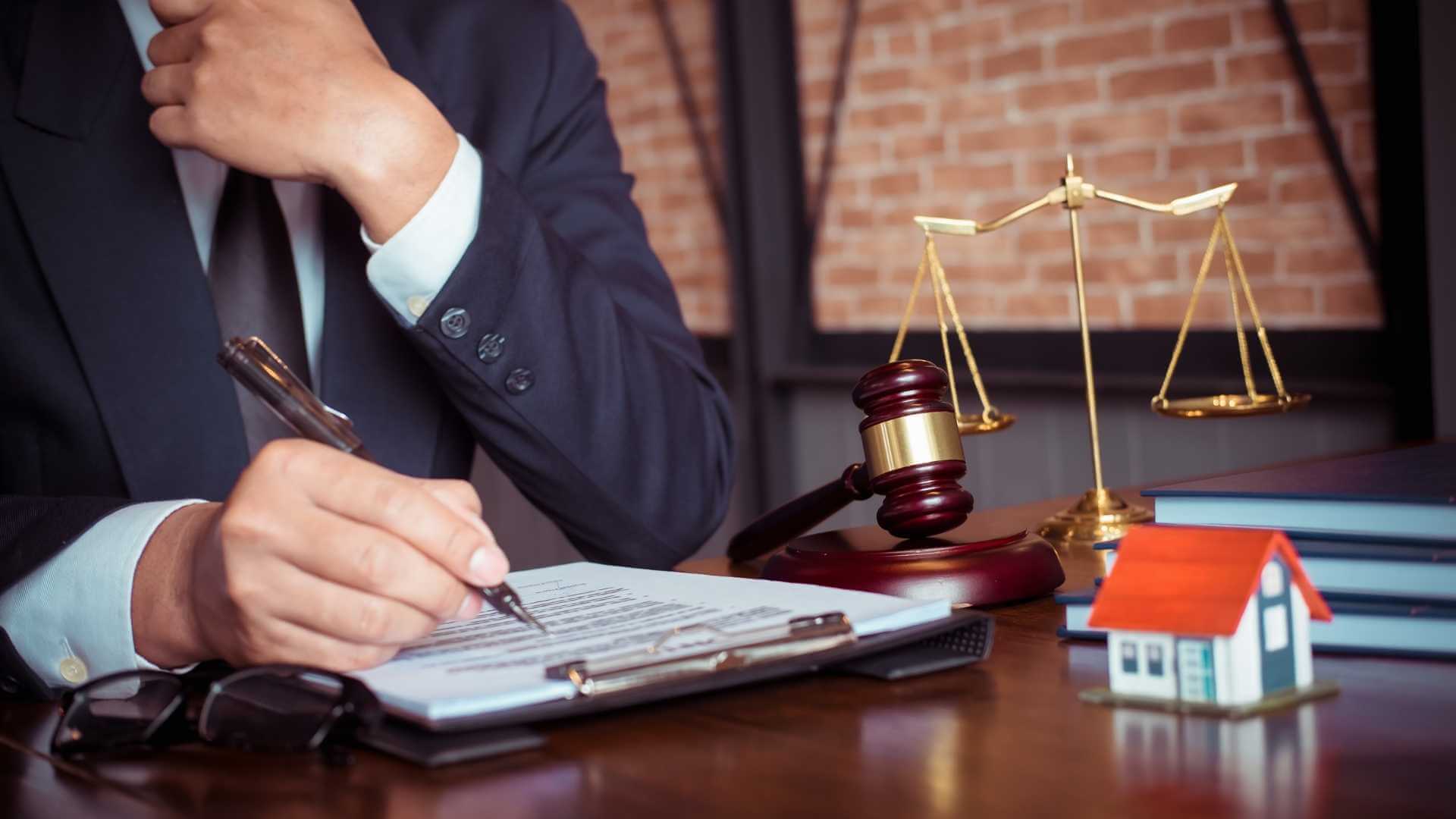 Cropped image of a lawyer in a blue suit writing a legal contract with a fountain pen